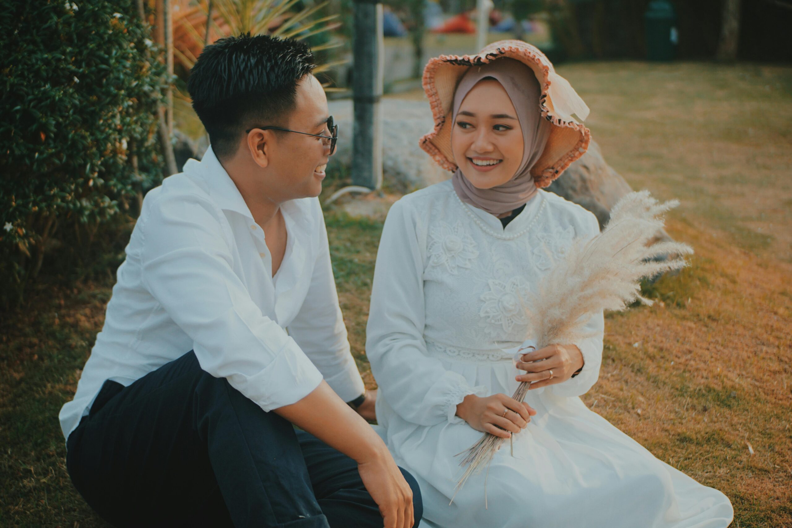 A man and woman sitting outdoors, sharing a joyful moment, illustrating togetherness and romance.